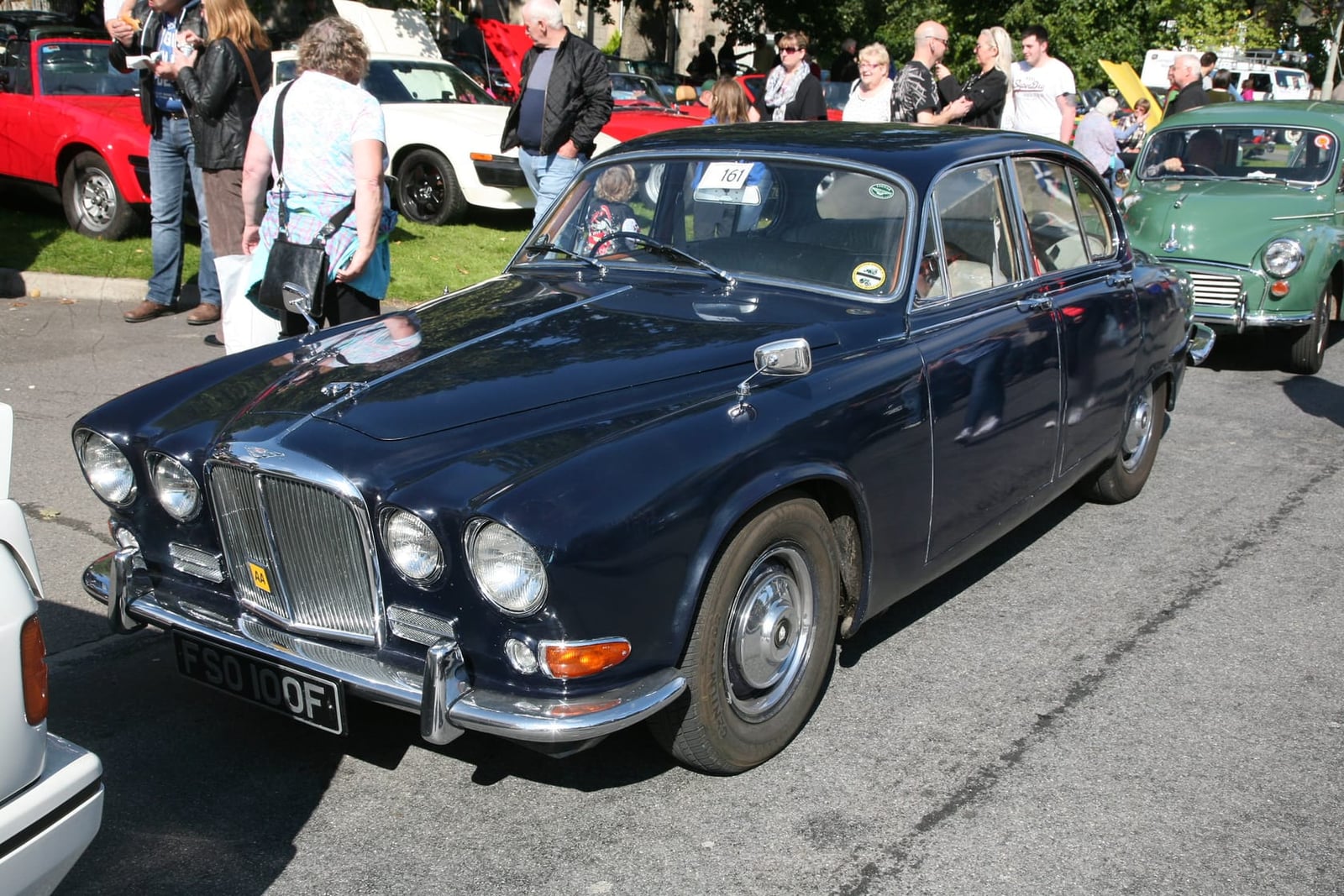 A dark blue 1967 Jaguar 420 compact saloon with four headlamps, front three-quarter view