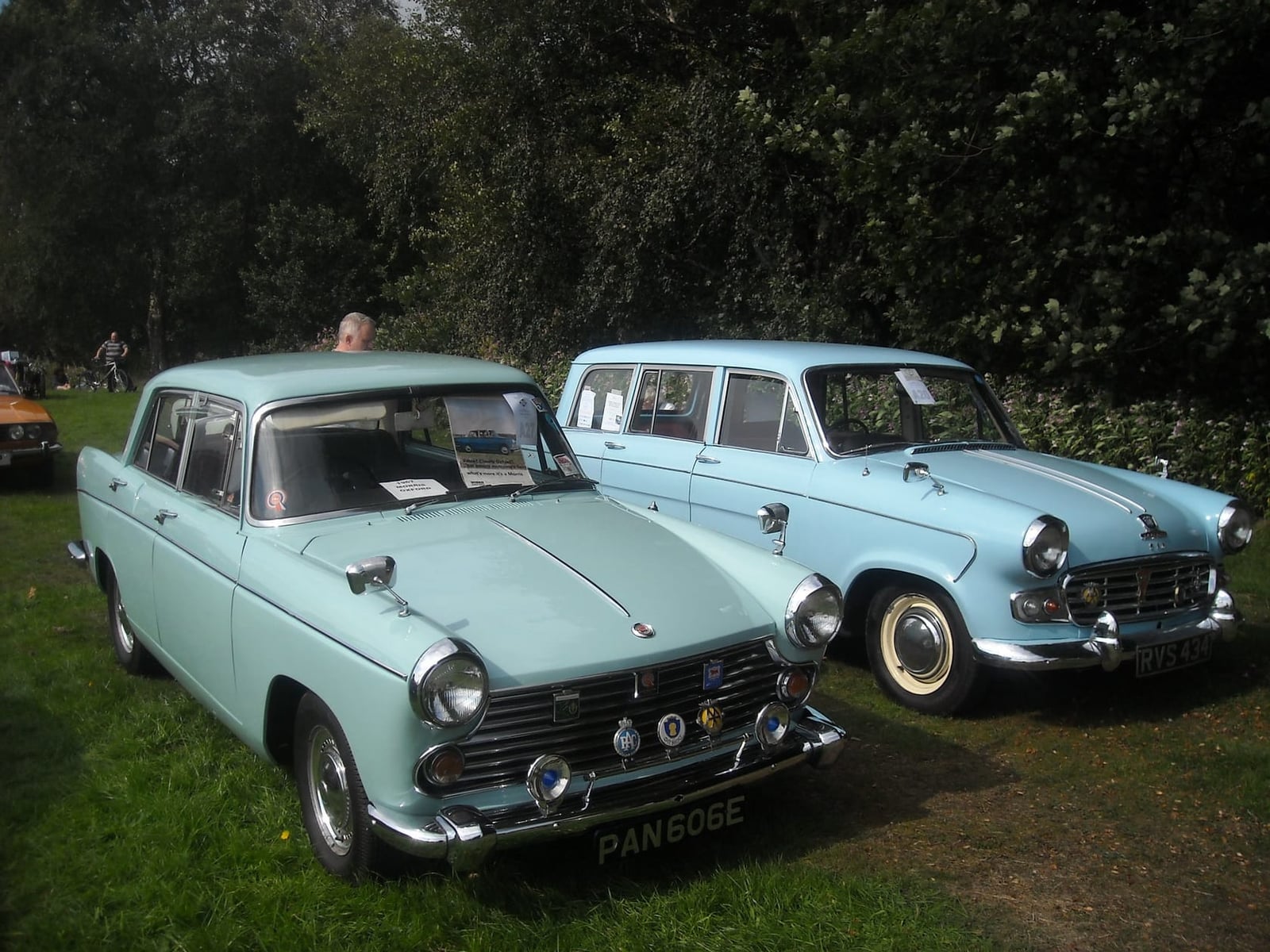 Two pale blue Morris Oxford Farina saloons parked together on grass