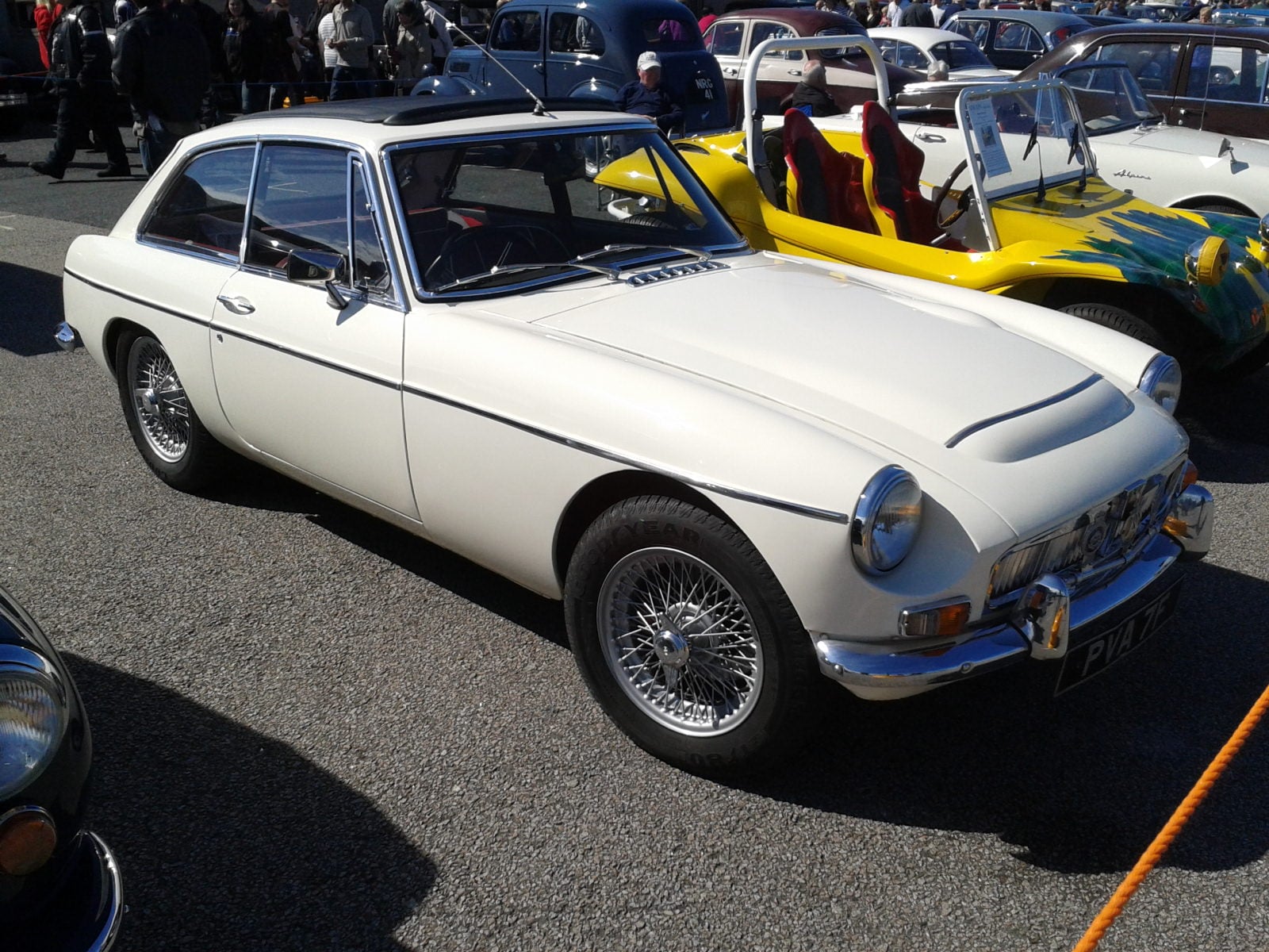 A white MG MGC GT, front three-quarter view by the water
