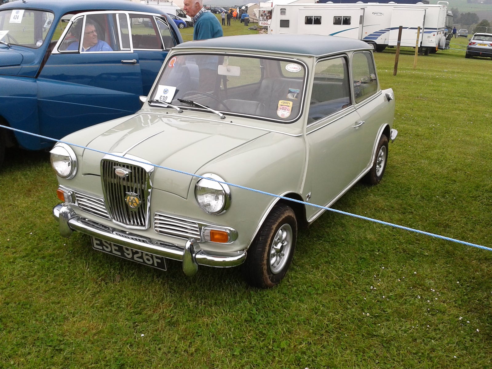 A grey Wolseley Hornet saloon at a show, front three-quarter view showing the Wolseley grille