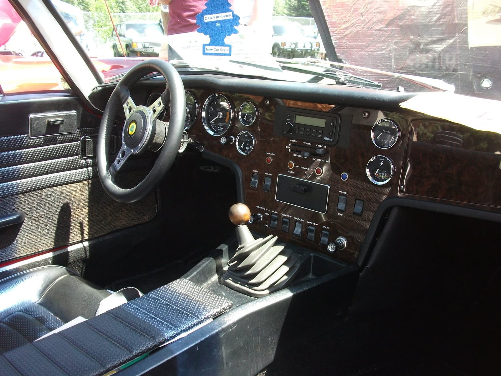 The dashboard of a 1969 Lotus Elan +2 with its wood veneer, round dials and gear lever