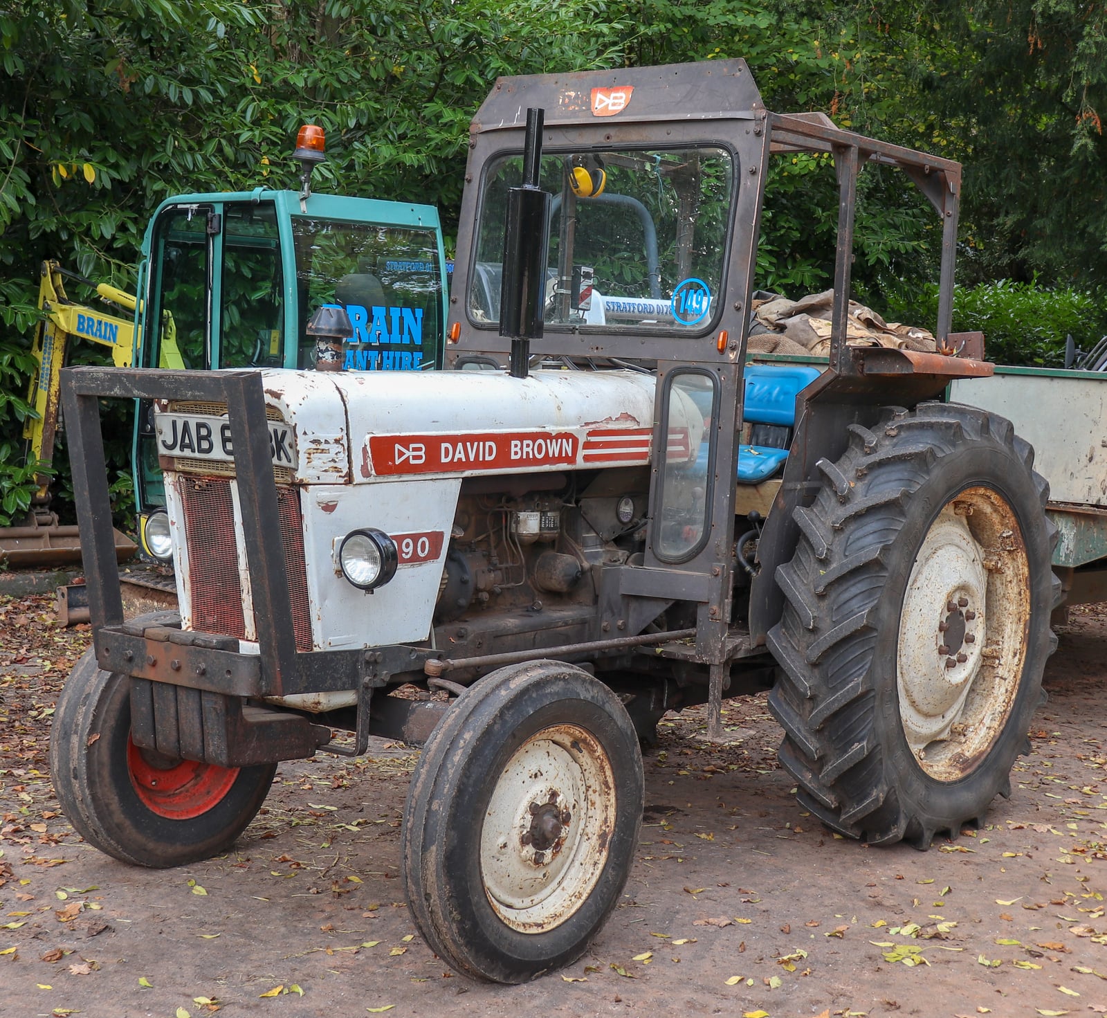 A white and blue cabbed David Brown 990 of 1971 parked in a yard