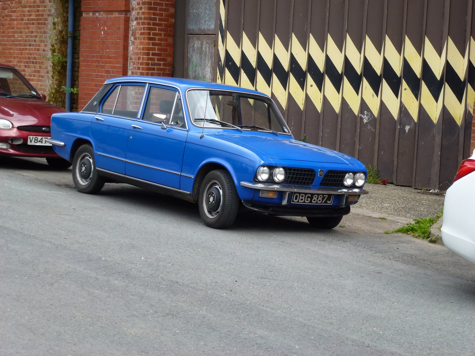A blue Triumph Dolomite saloon, front three-quarter view on a street