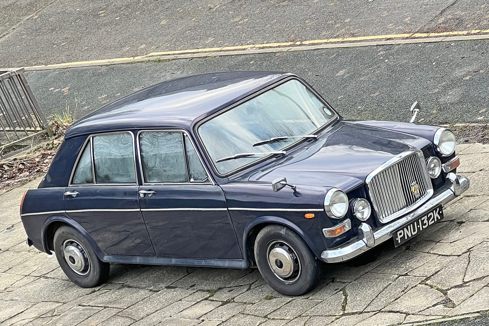 A dark blue 1971 Vanden Plas Princess 1300 parked on a paved street, front three-quarter view