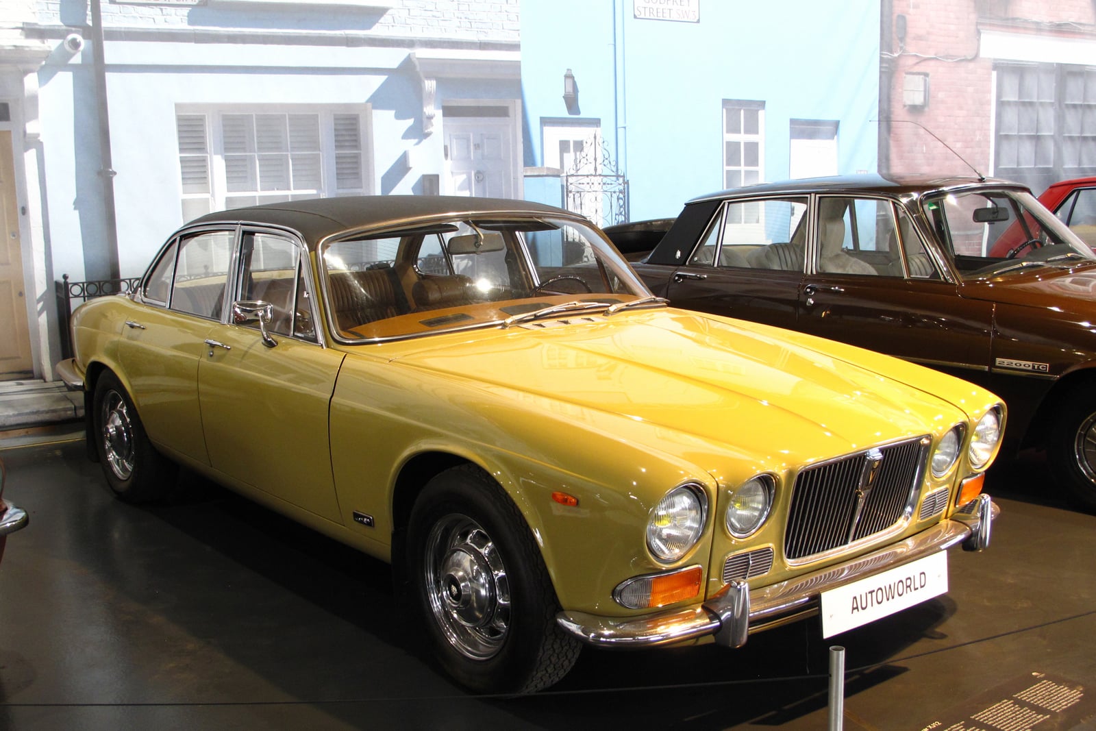 A gold Jaguar XJ12 Series 1 saloon with chrome bumpers, front three-quarter view
