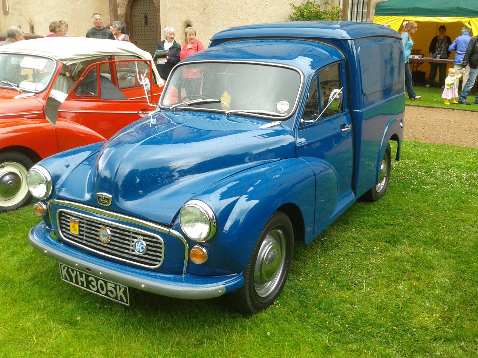 A blue Morris Minor van, front three-quarter view at a classic car show, UK registration KYH 305K