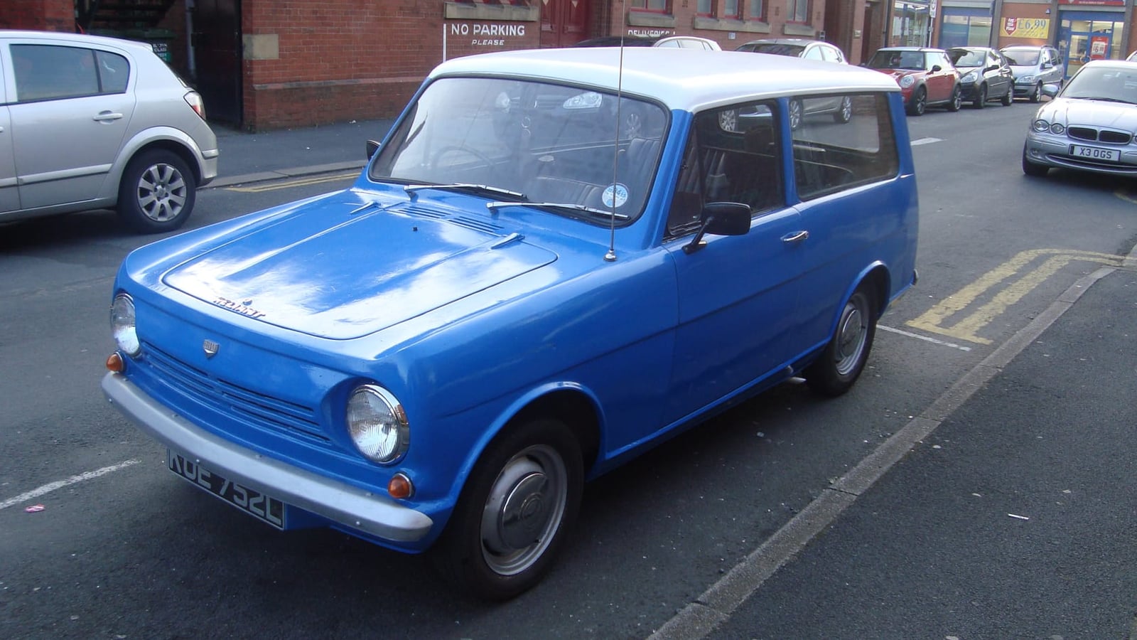 A blue 1972 Reliant Rebel 700 estate parked on a street, front three-quarter view, UK registration KUE 752L