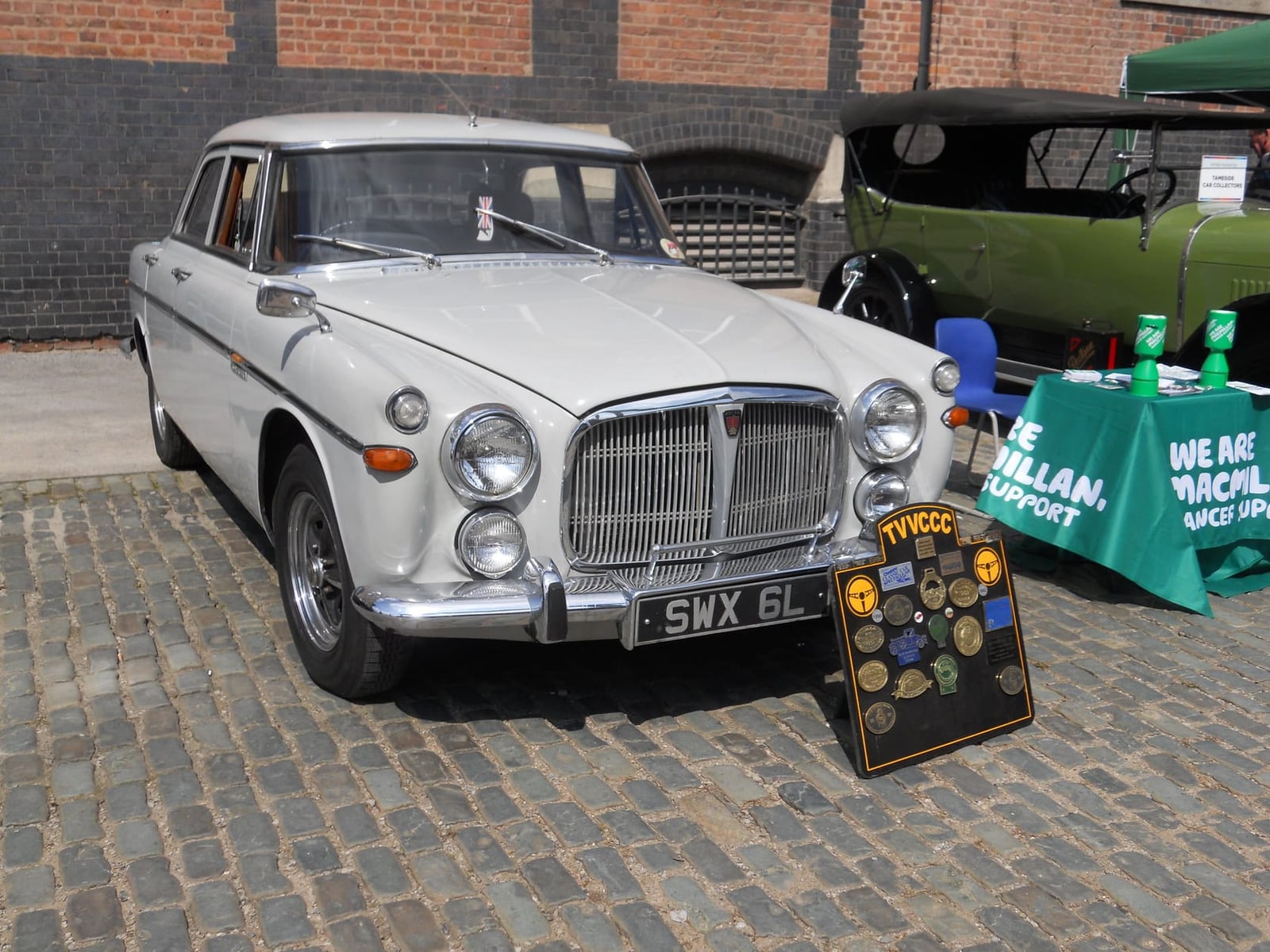 A white and grey Rover P5 3-Litre parked on cobbles with a club plaque displayed, UK registration SWX 6L