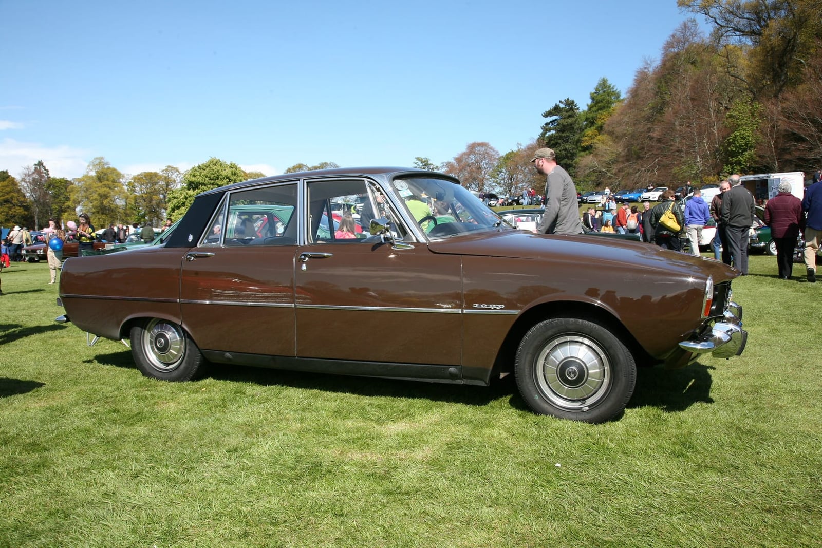 A brown Rover P6 in side profile on grass at a classic car show