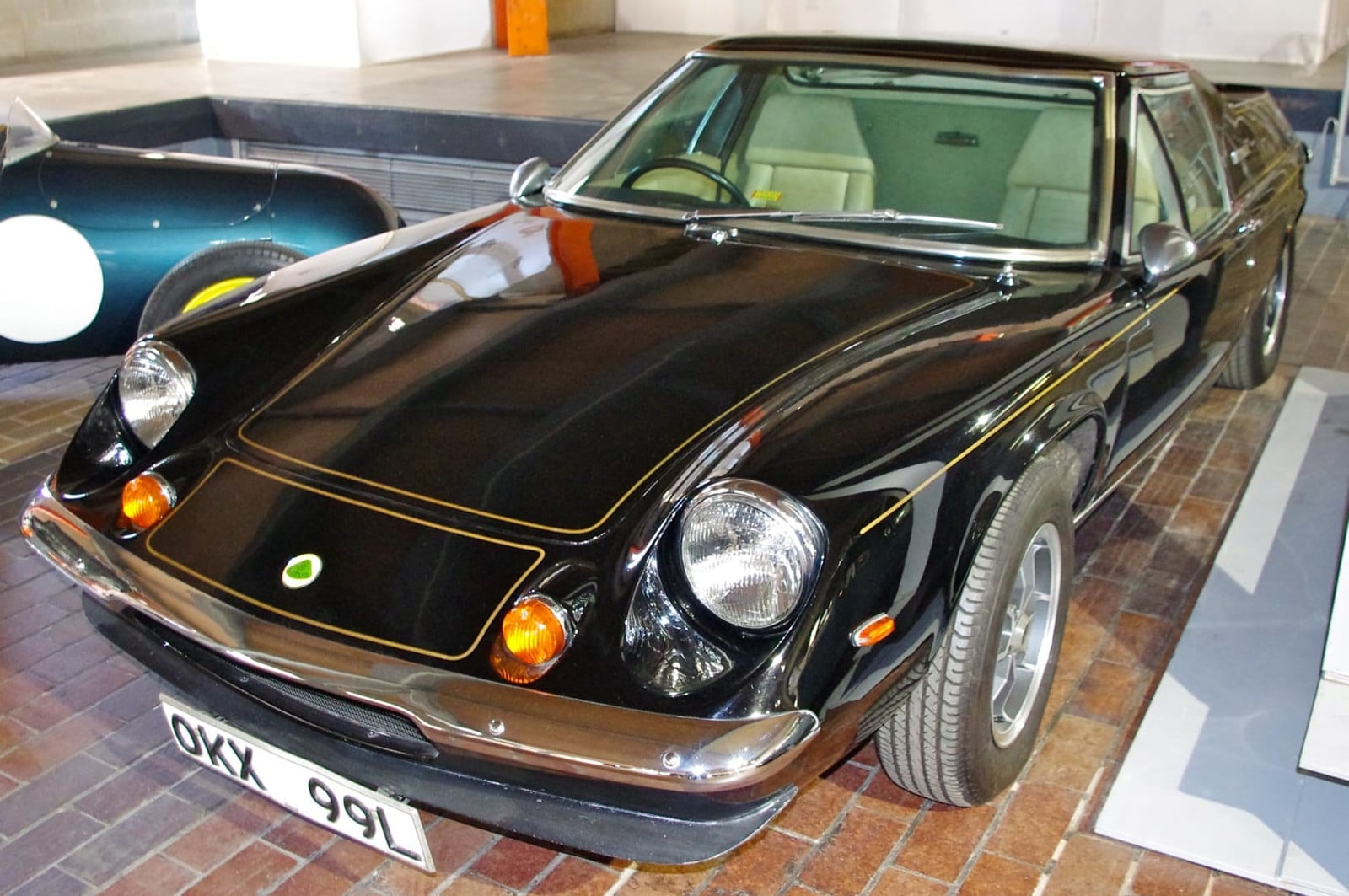 A black and gold 1973 John Player Special liveried Lotus Europa with UK registration OKX 991L displayed in a museum