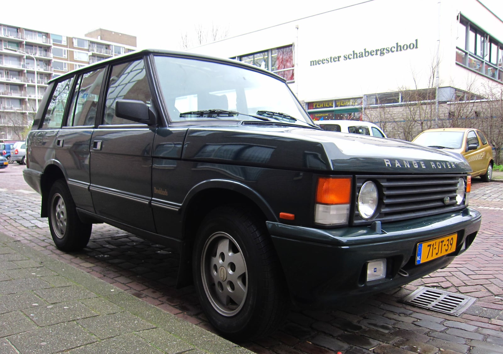 A dark four-door Range Rover Classic parked kerbside