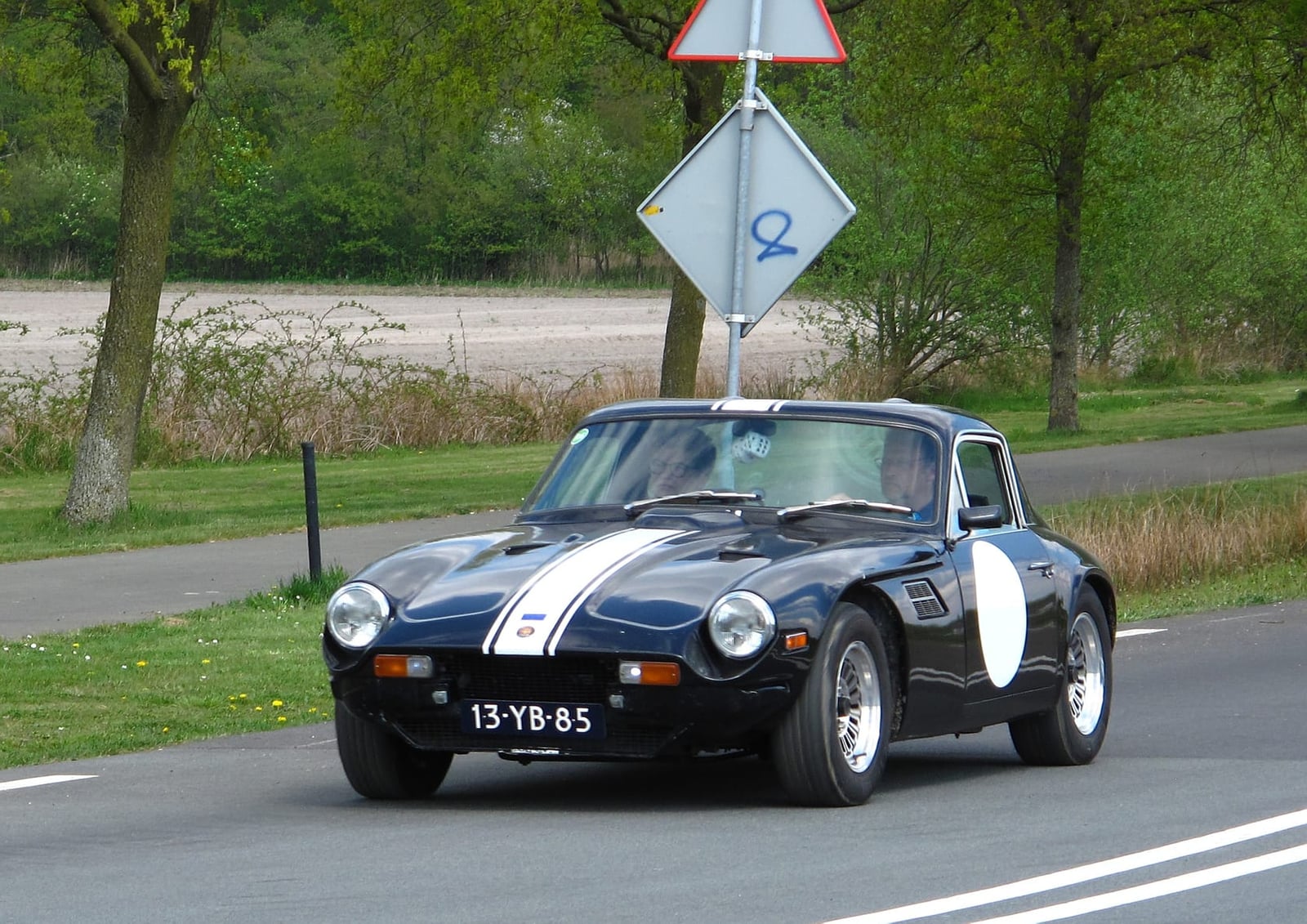 A black 1976 TVR 2500M with white stripes on a road, Dutch registration 13-YB-85