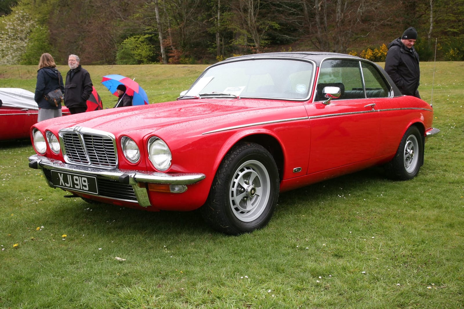A red 1977 Jaguar XJ-C 4.2 coupe parked on cobbles, rear three-quarter view