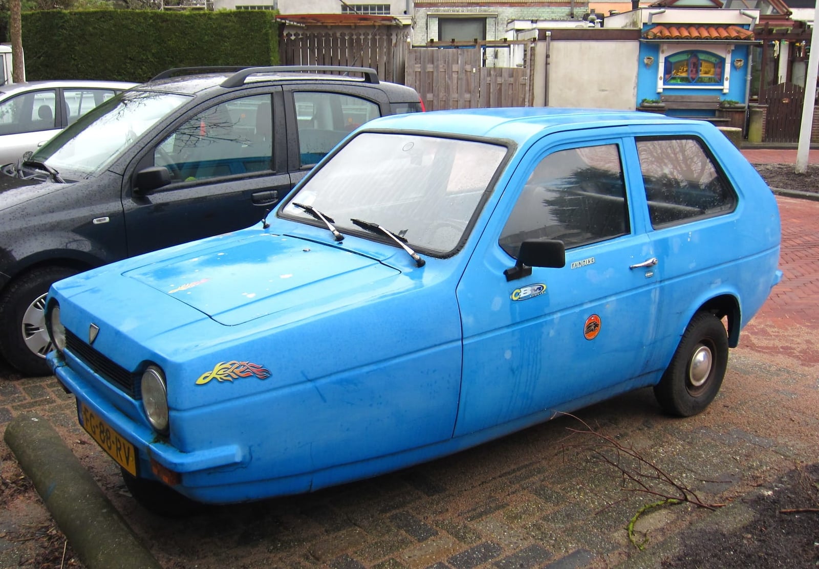 A light blue 1979 Reliant Robin 850 parked on a paved street, front three-quarter view