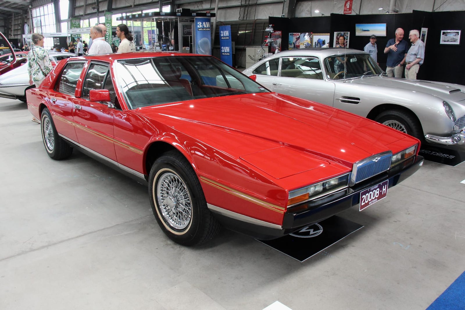 A red 1982 Aston Martin Lagonda Series 2 at an indoor show