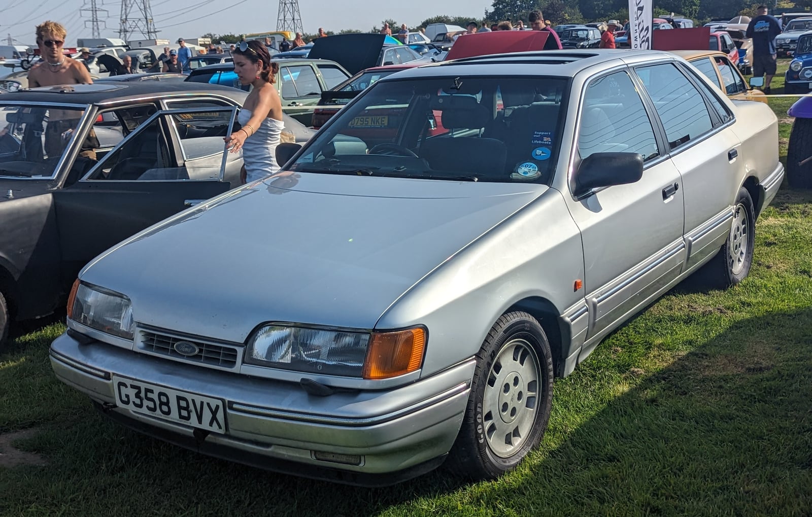 A dark red Ford Scorpio 24v Cosworth, front three-quarter view at a classic car show