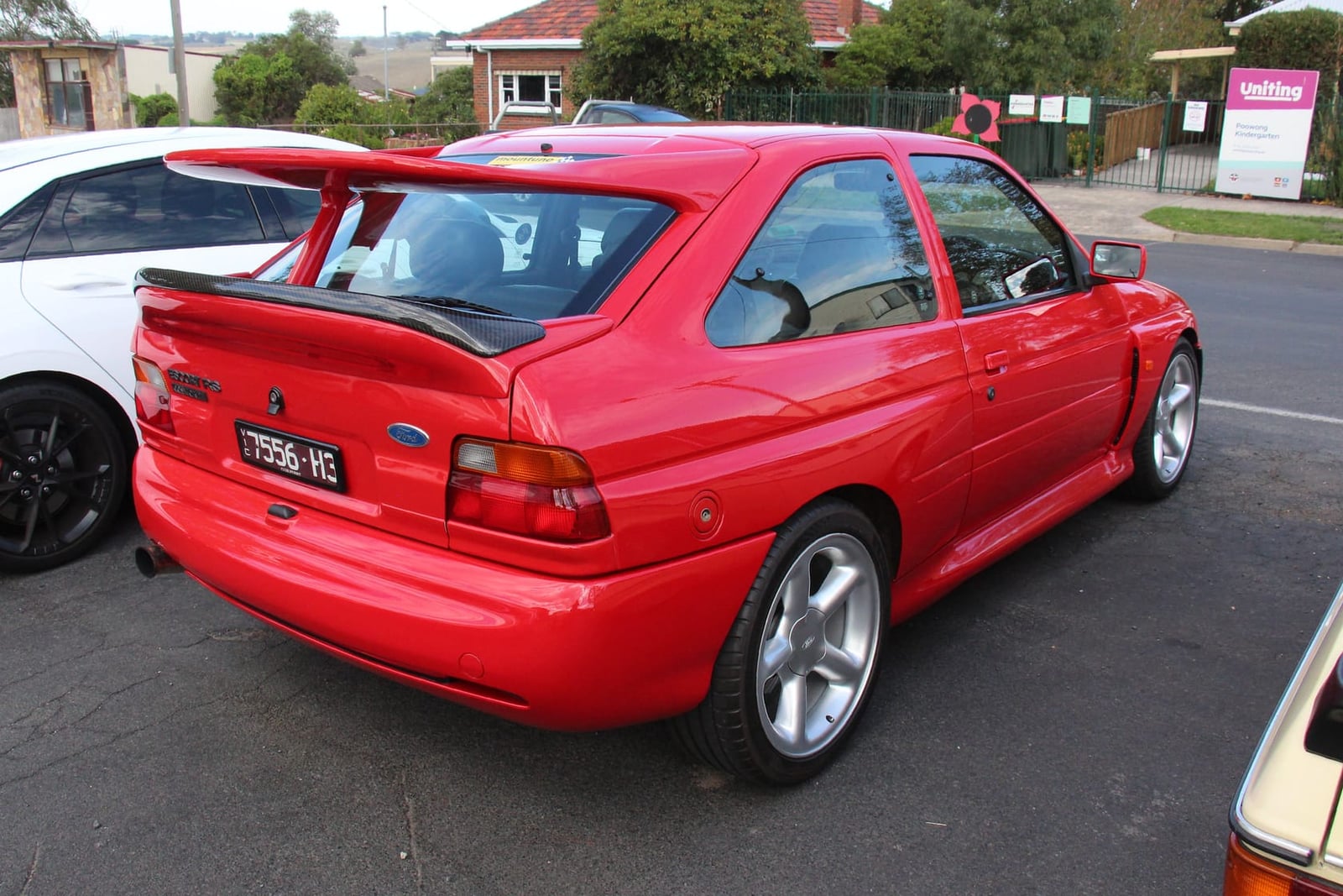 The rear of a red Ford Escort RS Cosworth showing the twin-plane whale-tail wing and wide arches