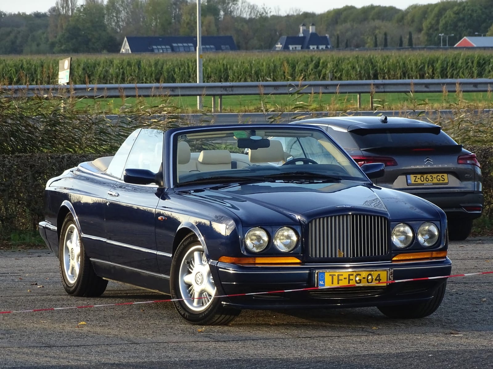 A dark blue 1996 Bentley Azure convertible with tan interior and the roof down