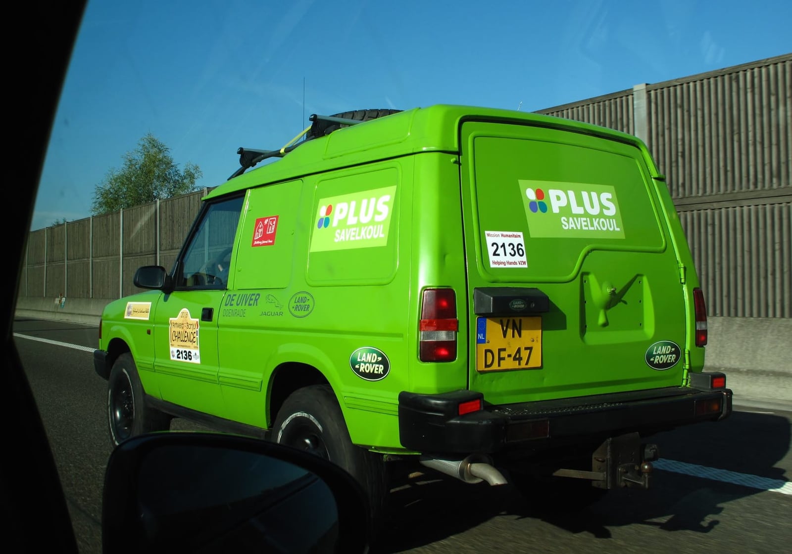 A green Land Rover Discovery Commercial van in Dutch supermarket delivery livery, rear three-quarter view