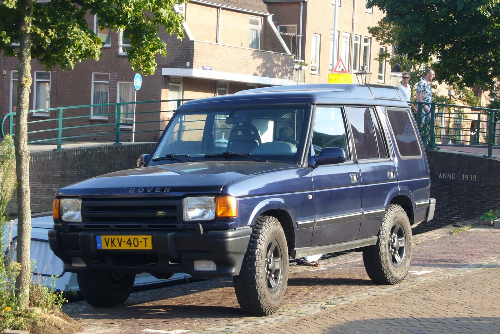 A blue 1998 Land Rover Discovery 300Tdi parked on a street, front three-quarter view