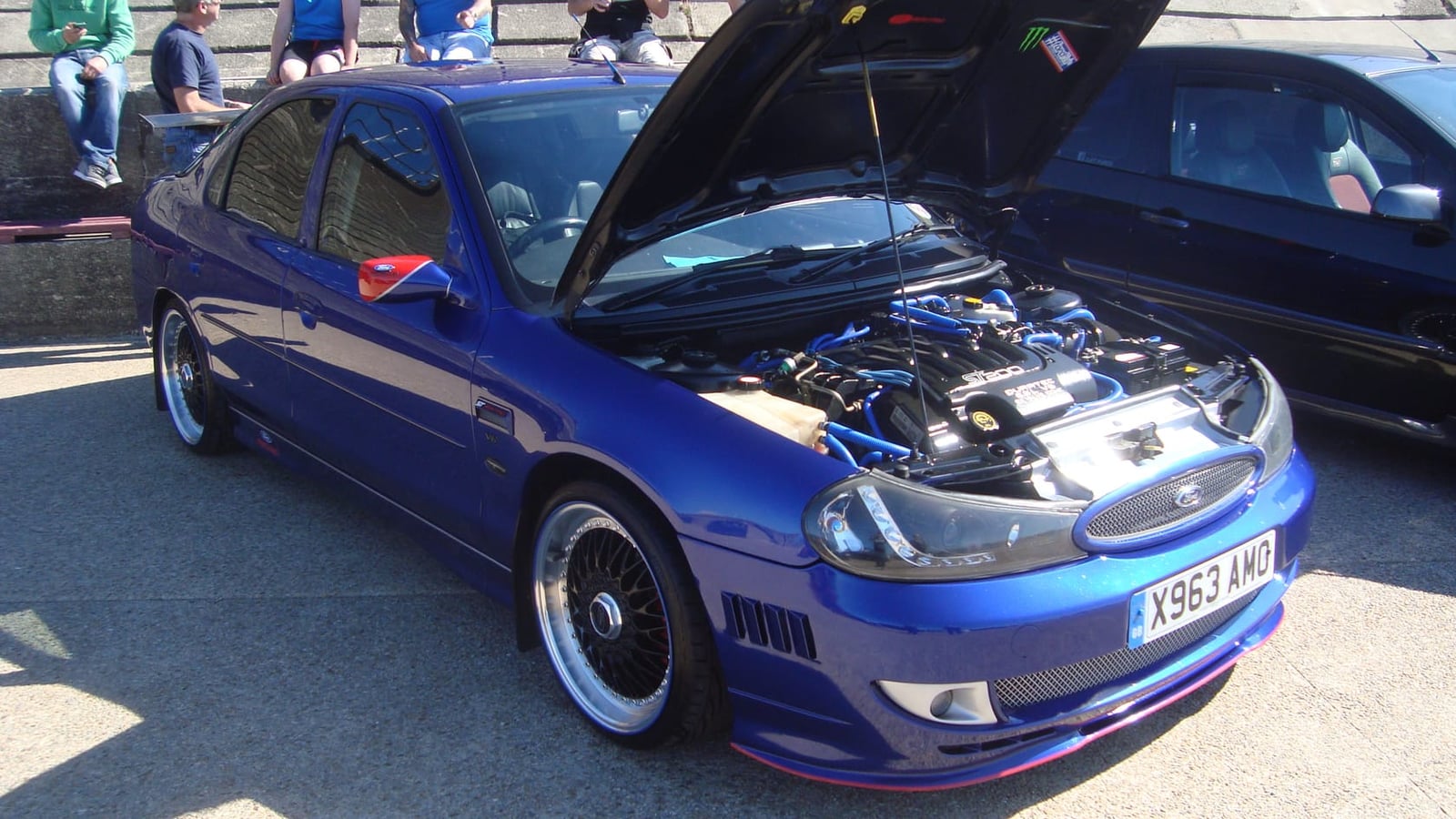 A modified Ford Mondeo ST200 at a show with its bonnet raised, on aftermarket wheels and lowered