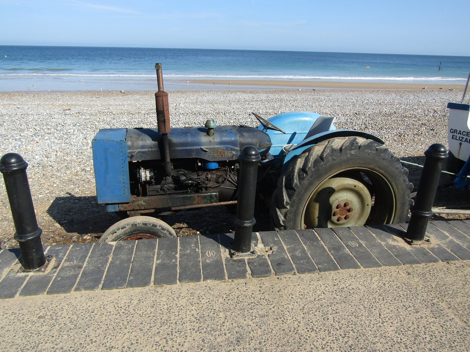 A weathered blue Fordson Major parked on the promenade at Cromer beach, Norfolk
