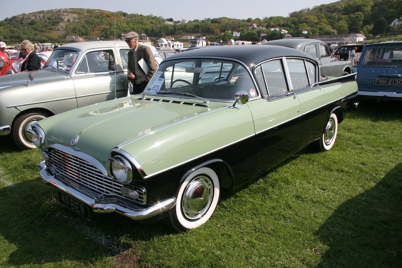 A green and black two-tone 1961 Vauxhall Cresta PA at a show, front three-quarter view, UK registration 411 BEW