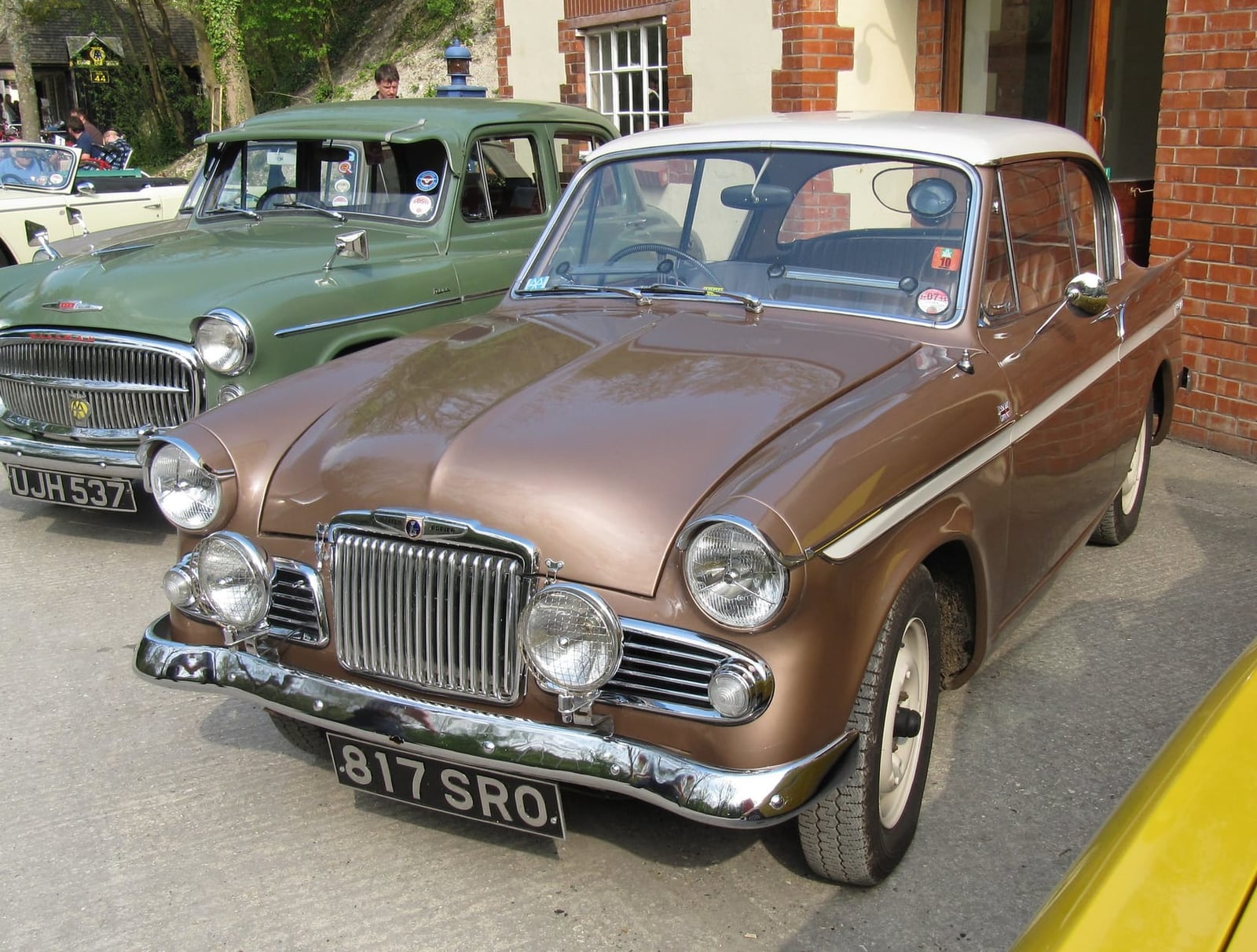 A gold and cream two-tone 1963 Sunbeam Rapier Series car on display at a museum, front three-quarter view, UK registration 817 SRO