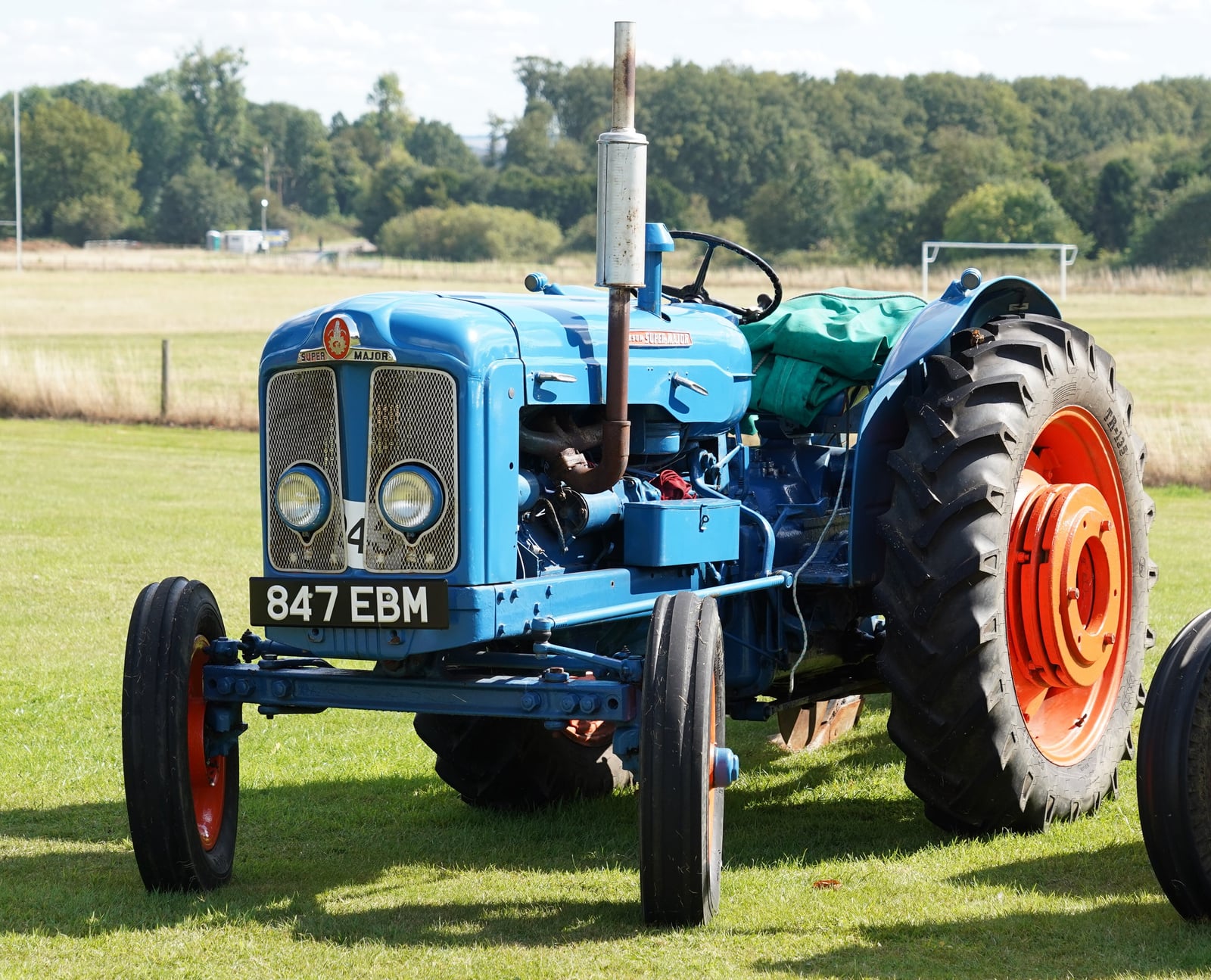 A blue and orange Fordson Super Major with the registration 847 EBM, front three-quarter view on a show field