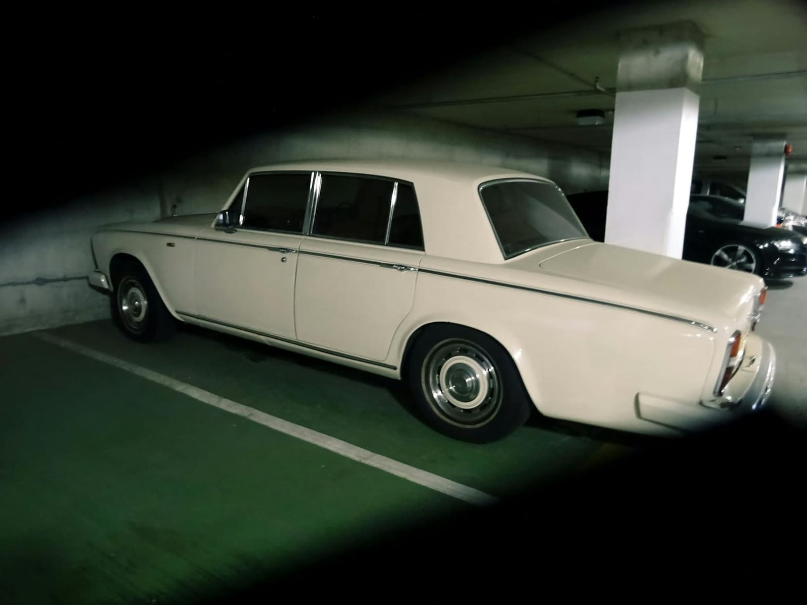 A cream Rolls-Royce Silver Shadow parked in an underground car park