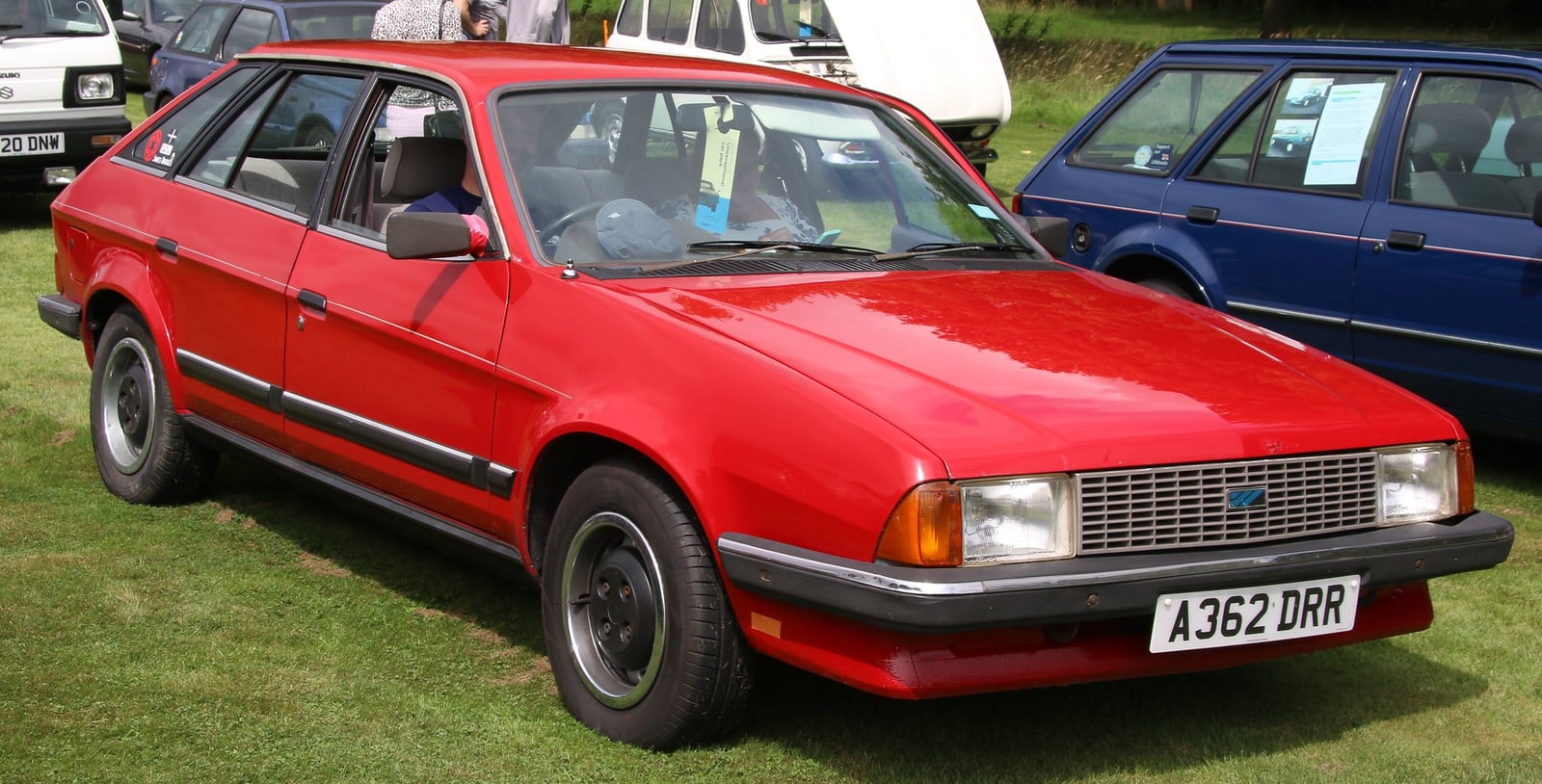 A bright red 1983 Austin Ambassador 2.0HL hatchback (A plate), front three-quarter view at an outdoor classic car show