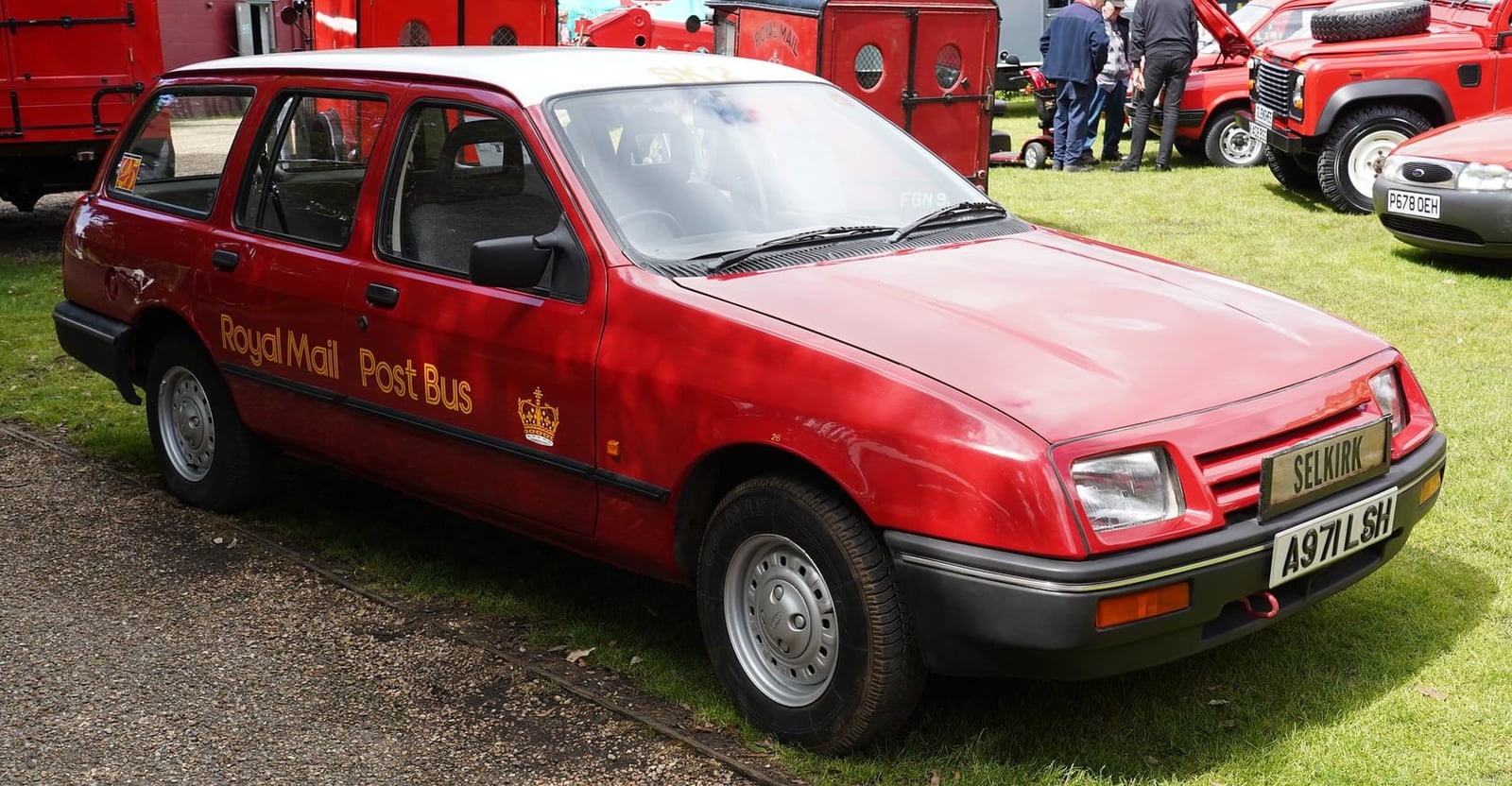 A red Royal Mail Post Bus Ford Sierra estate on grass at a vehicle rally, UK registration A971 LSH