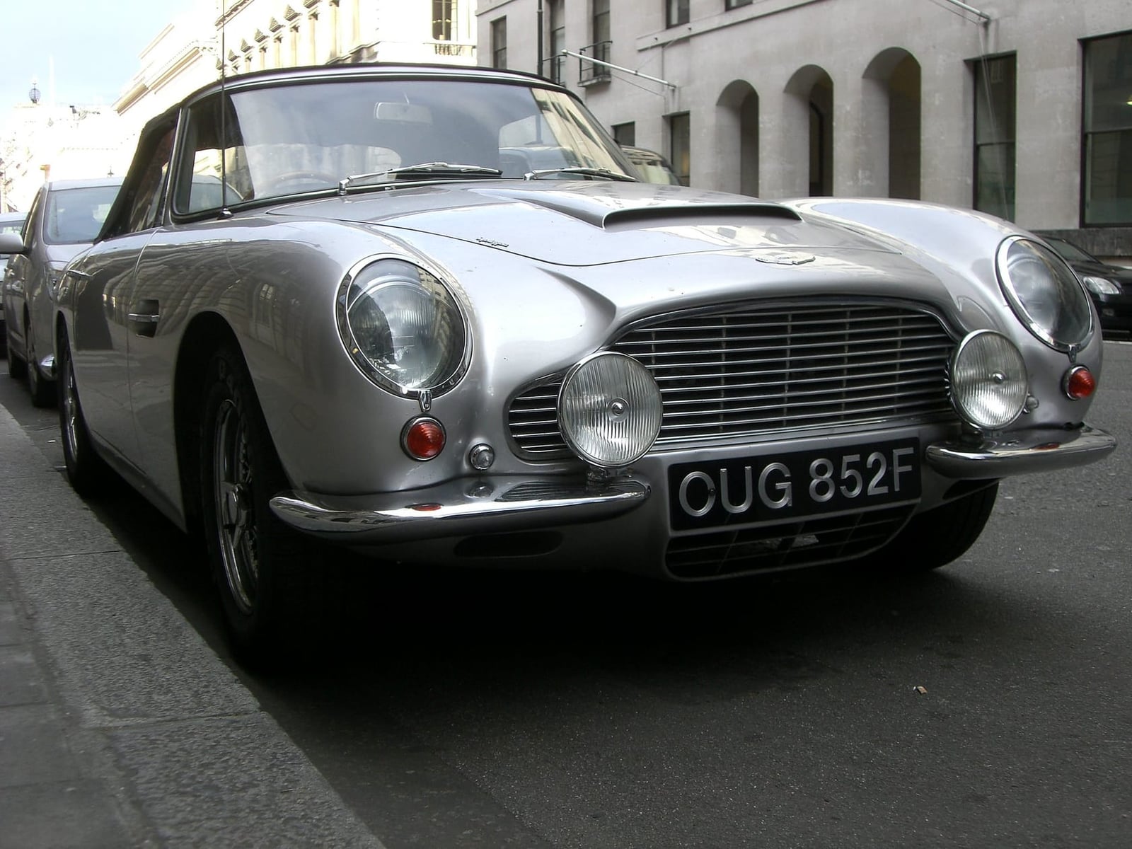 A silver Aston Martin DB5 with UK registration OUG 852F parked on Pall Mall in London