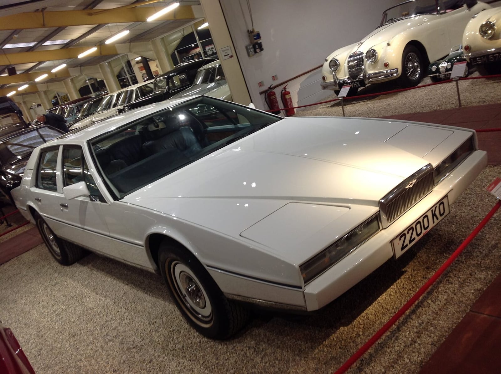 A silver 1982 Aston Martin Lagonda wedge saloon in a workshop