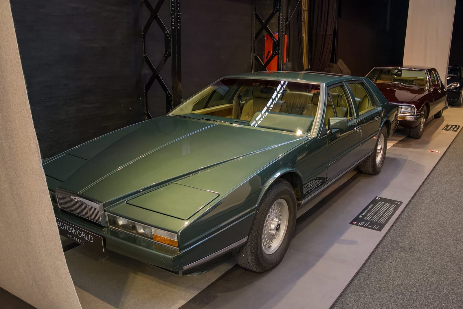 A green Aston Martin Lagonda Series 3 displayed in a museum