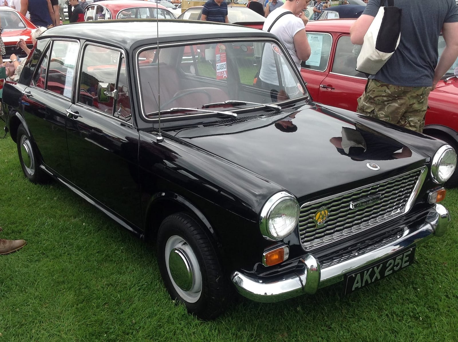 A black 1967 Austin 1100 at a classic car show, front three-quarter view, UK registration AKX 20E