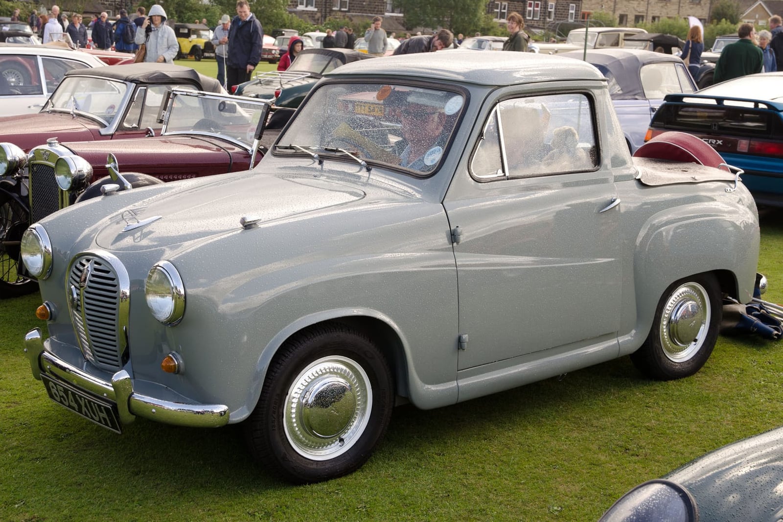 A grey 1957 Austin A35 pickup at a classic vehicle show, front three-quarter view