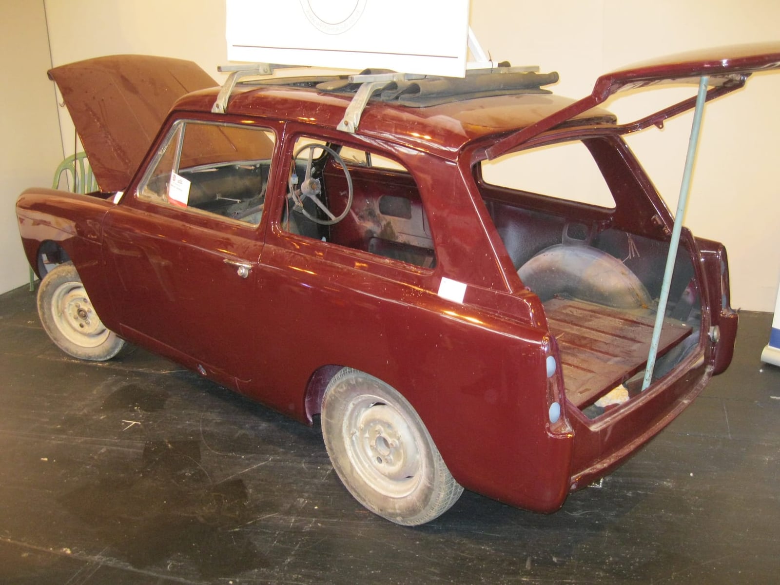 A maroon Austin A40 Farina Countryman part-way through restoration with panels removed