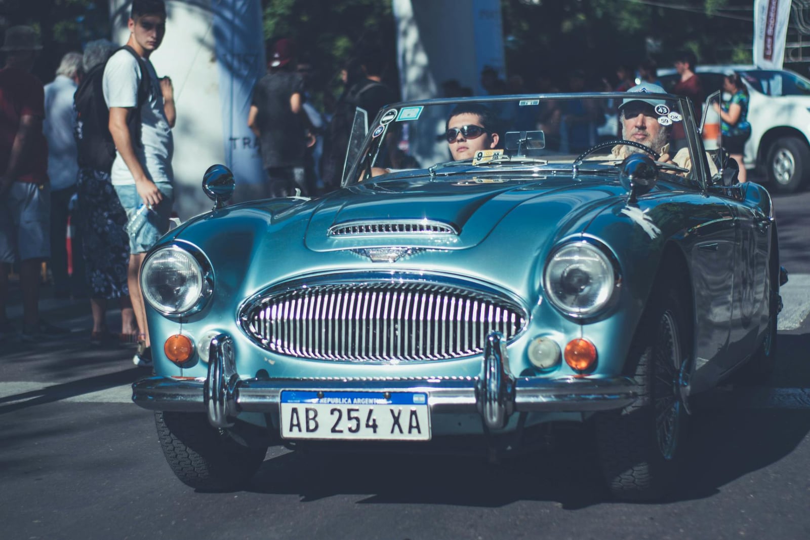 A light blue Austin-Healey 3000 with two crew on a classic-car rally