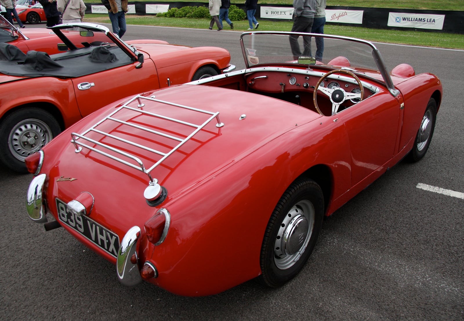 A red Austin-Healey Frogeye Sprite seen from the rear at a show