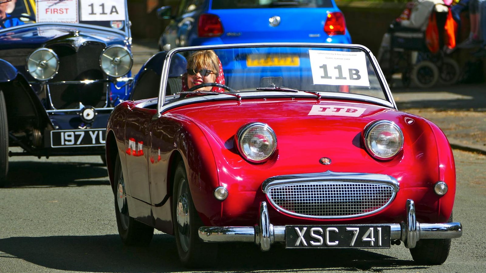 A red Austin-Healey Frogeye Sprite on a classic-car run