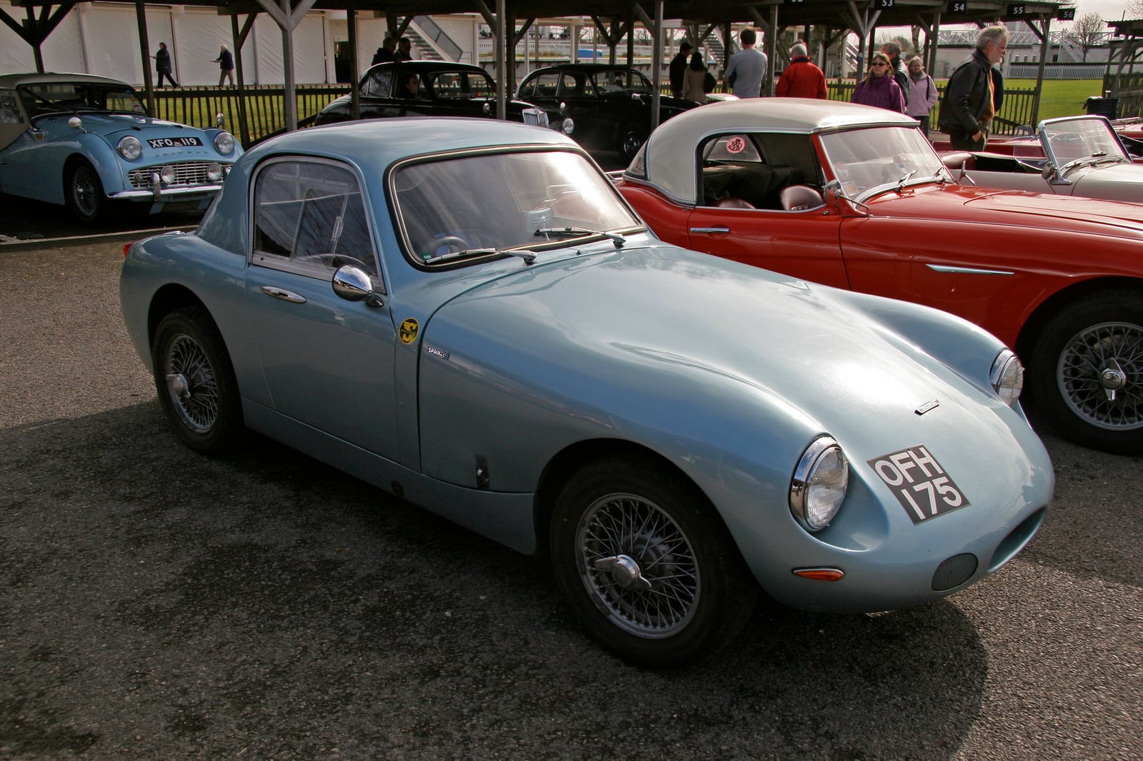 A silver-blue Sebring Sprite competition coupe at a circuit