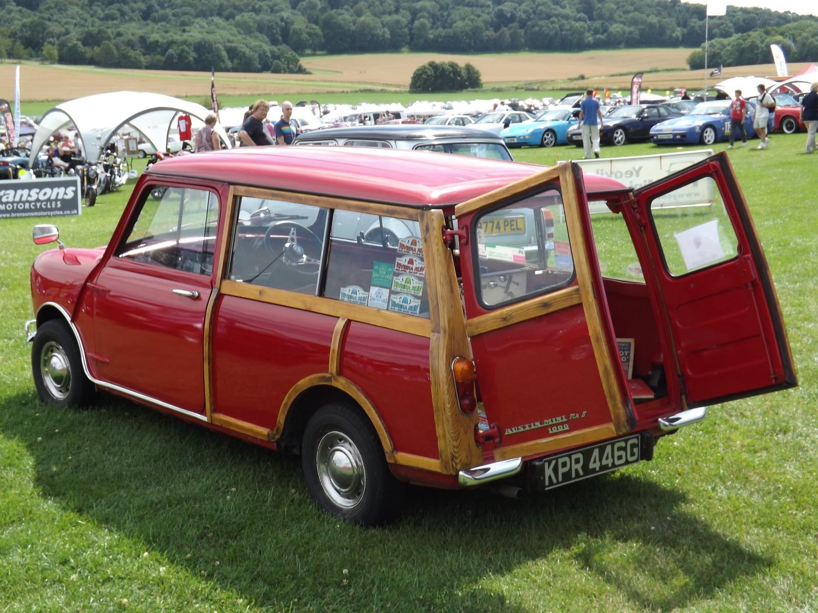 A red woody Austin Mini Countryman with its rear doors open, rear three-quarter view
