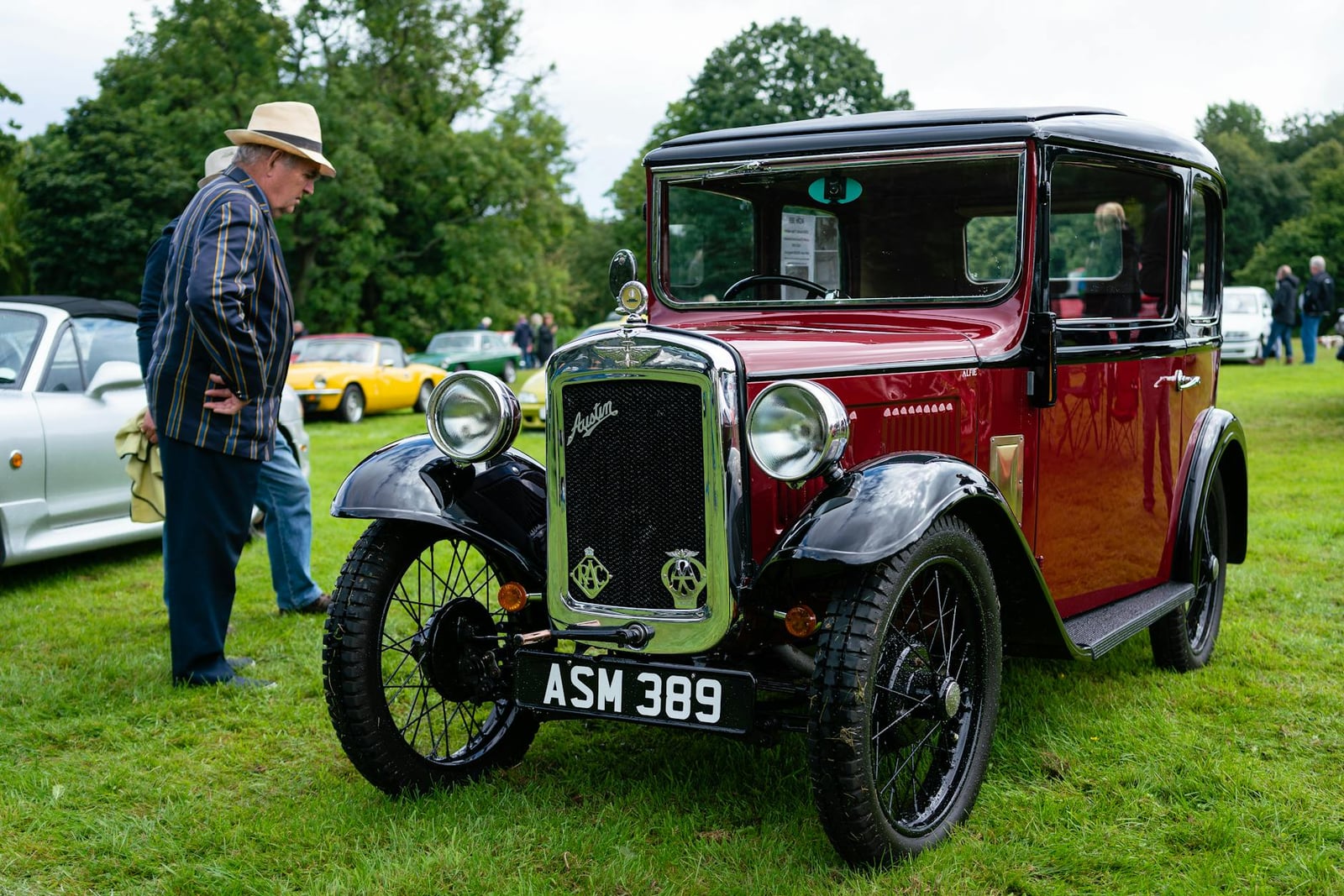 A maroon and black Austin Seven Ruby saloon at a show, front three-quarter view, UK registration ASM 389