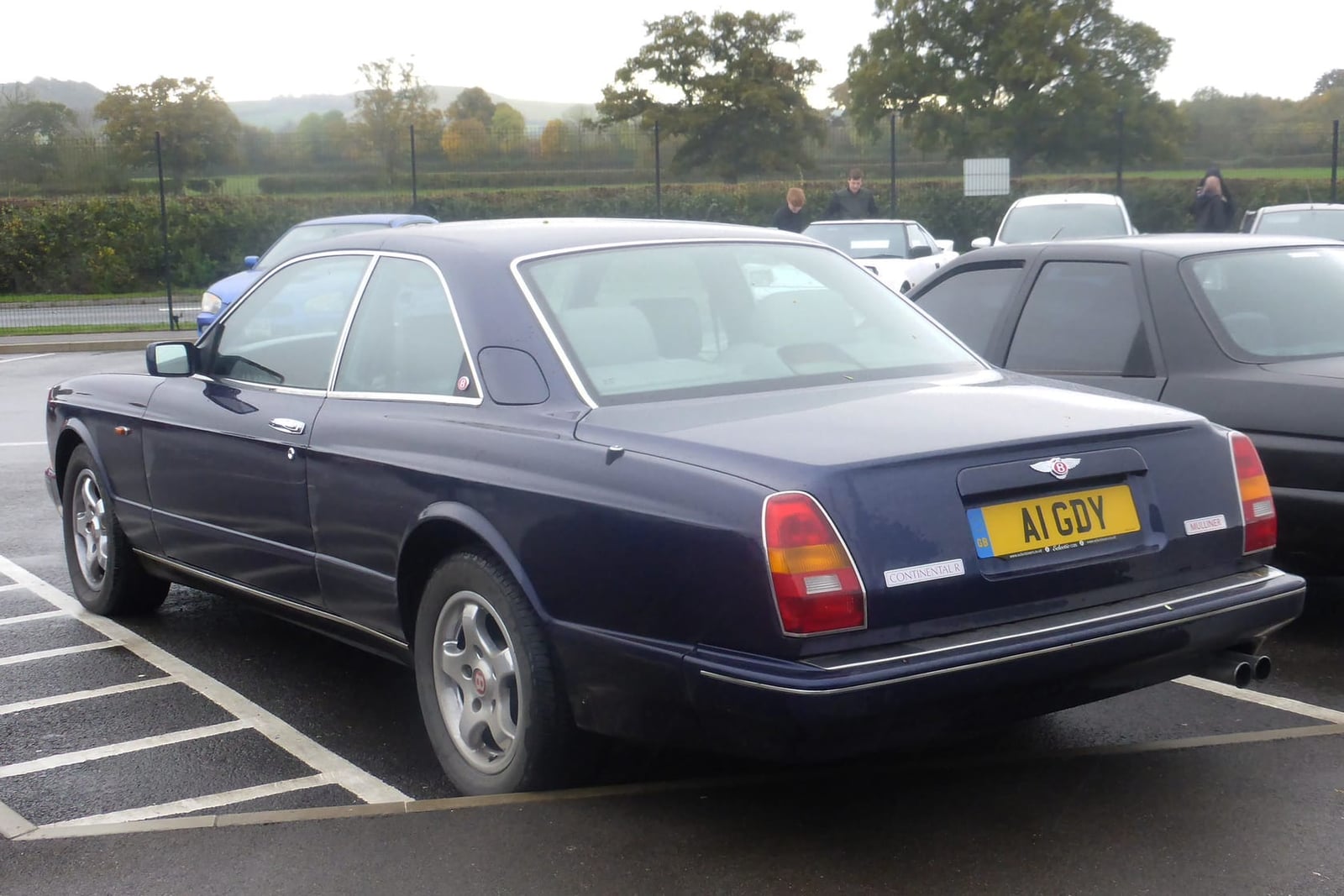 The rear of a dark blue Bentley Continental R in a car park