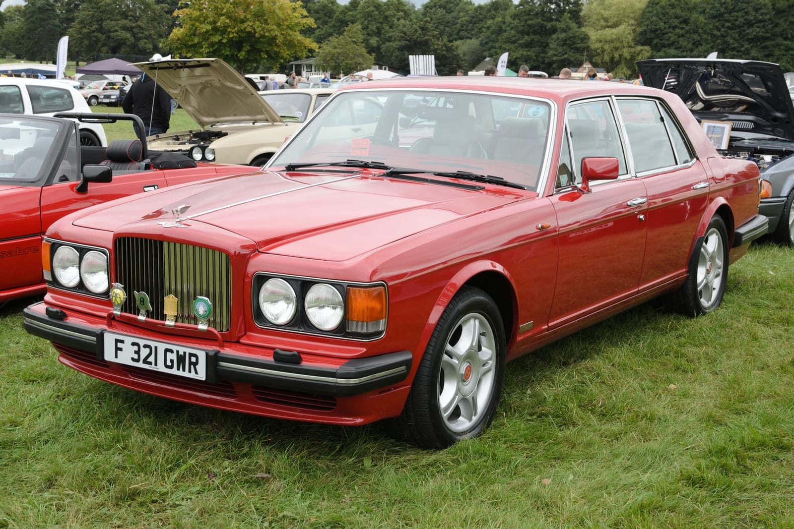 A red 1989 Bentley Turbo R with UK registration F321 GMR on a show field