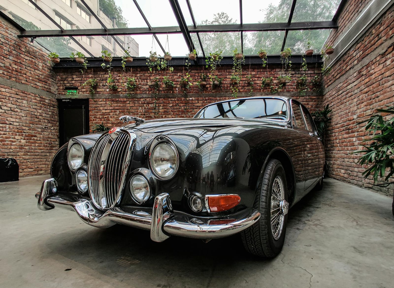 A dark Jaguar Mk2 saloon with chrome wire wheels