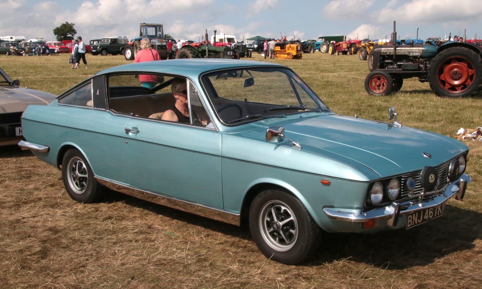A light blue Sunbeam Rapier fastback coupe on a showfield, front three-quarter view, UK registration BNJ 467K