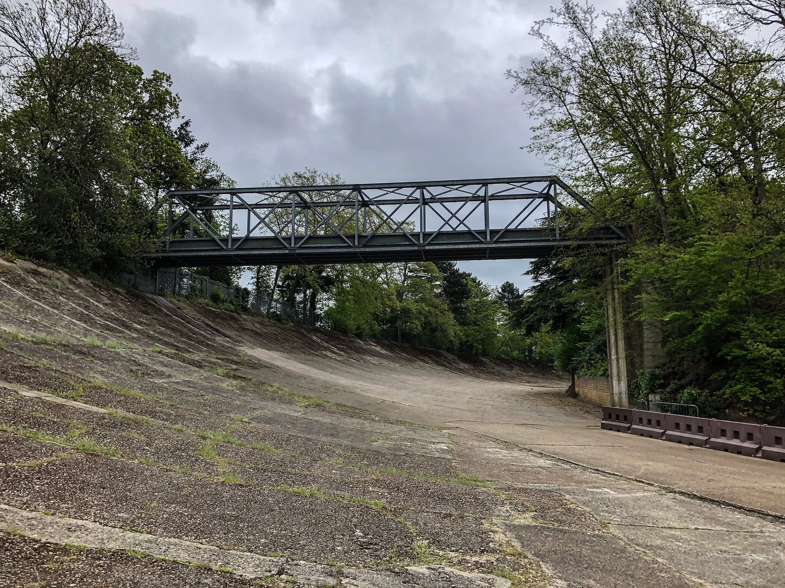 A surviving section of the steeply banked concrete racing circuit at Brooklands in Surrey, with a footbridge crossing it