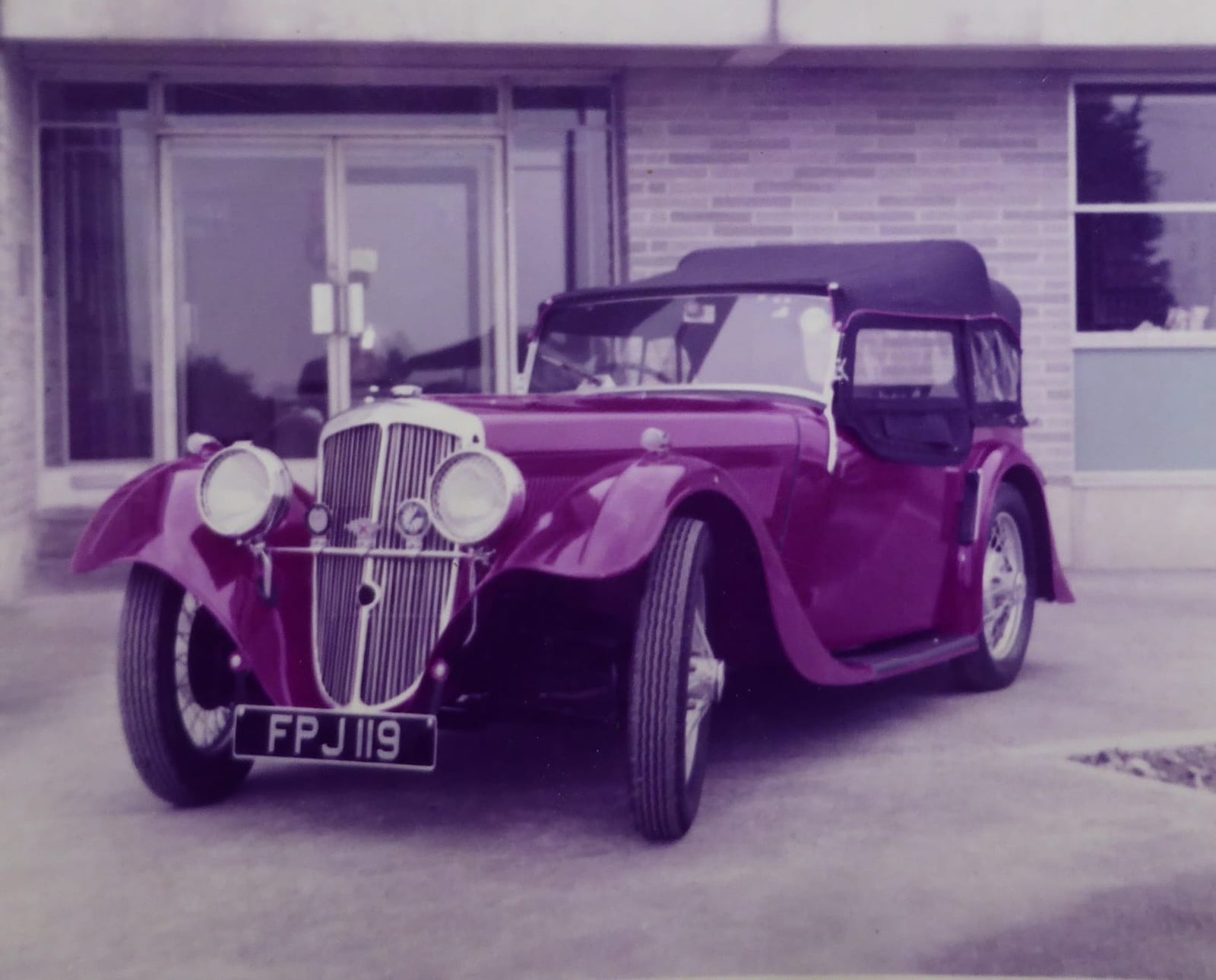 A period photograph of a 1937 BSA Scout 10hp tourer with its hood raised, UK registration FPJ 119